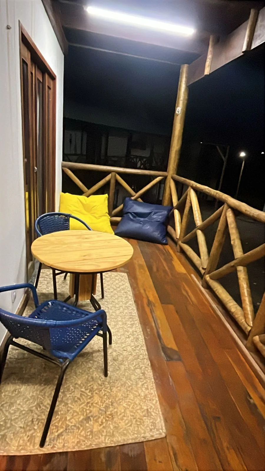 Varanda com mesa e cadeiras à noite.