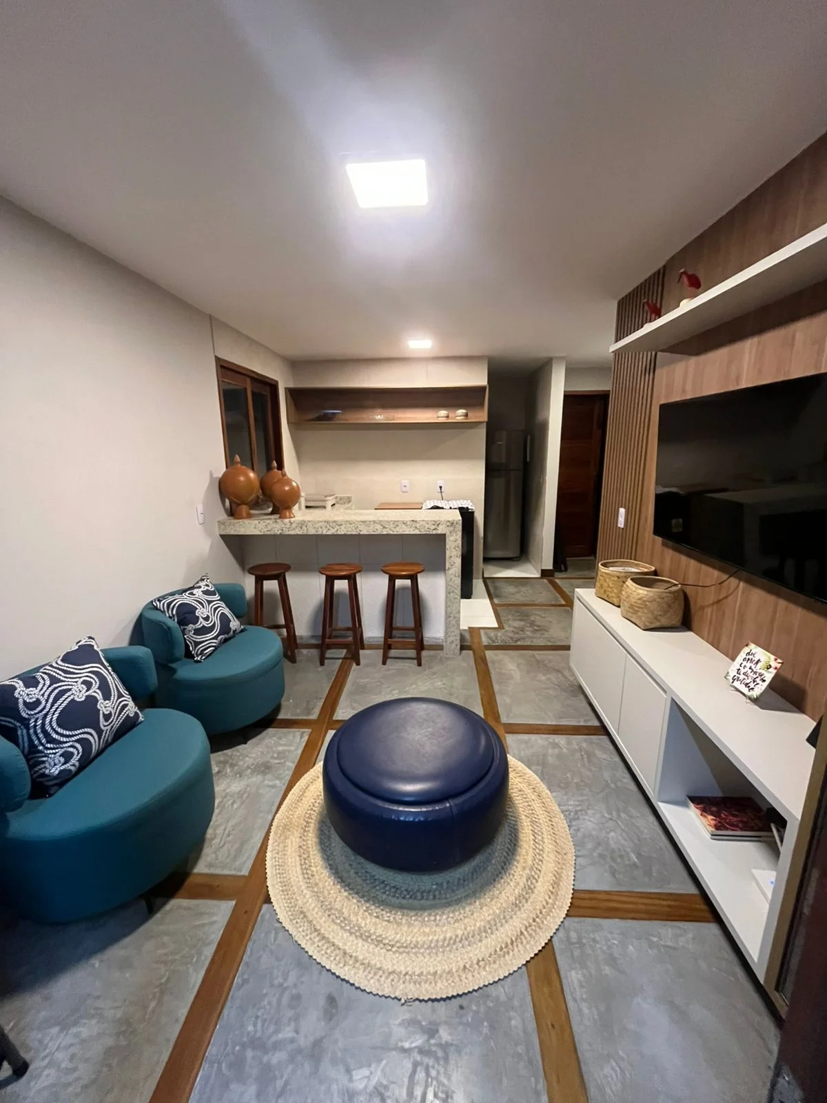 Sala e cozinha nos Chalés Barra Grande, com móveis azuis.
