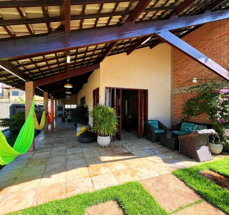 Varanda coberta com redes e jardim na Casa Luís Correia.