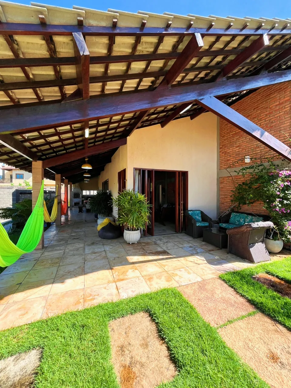 Varanda coberta com redes e jardim na Casa Luís Correia.