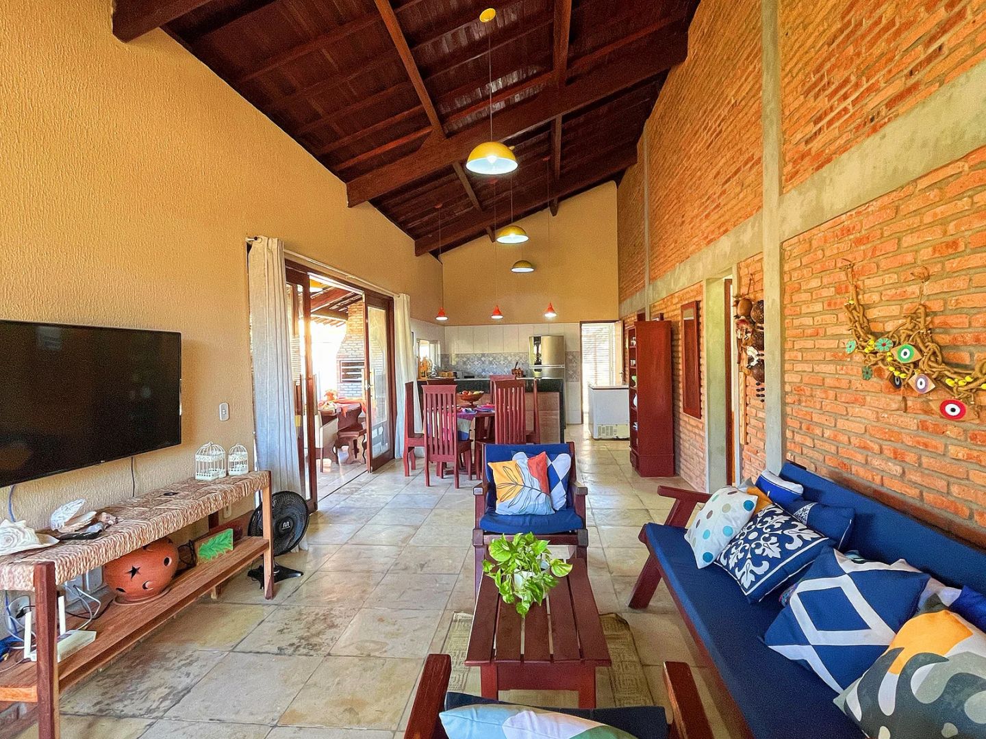 Sala com móveis de madeira e almofadas azuis.